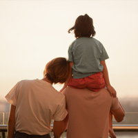 Family with one kids enjoying amazing view of setting sun outdoors in spring.