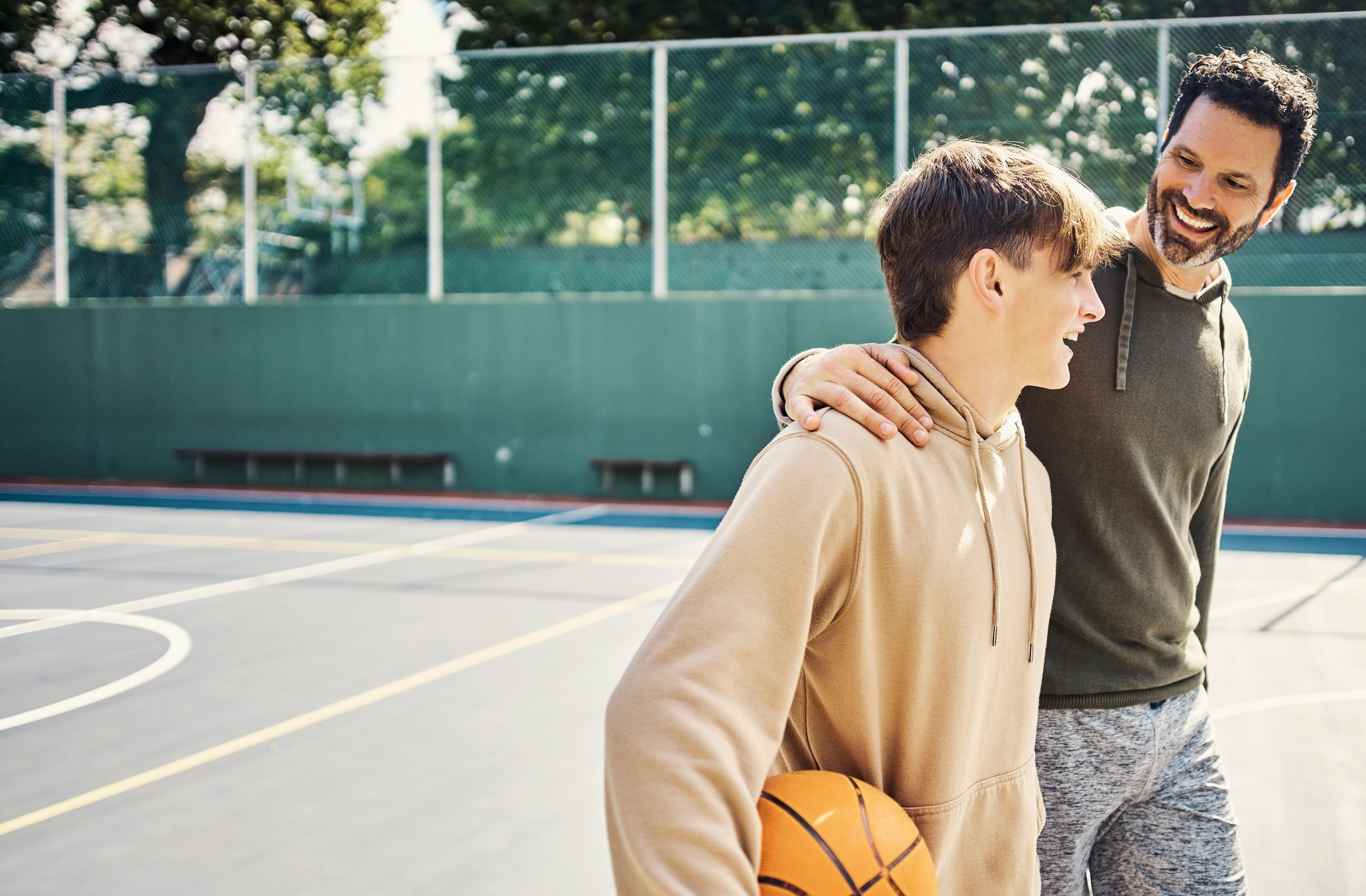 Father and son walking after playing a game of basketball.