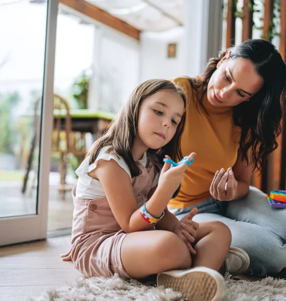Practitioner sitting on floor with a neurodiverse child