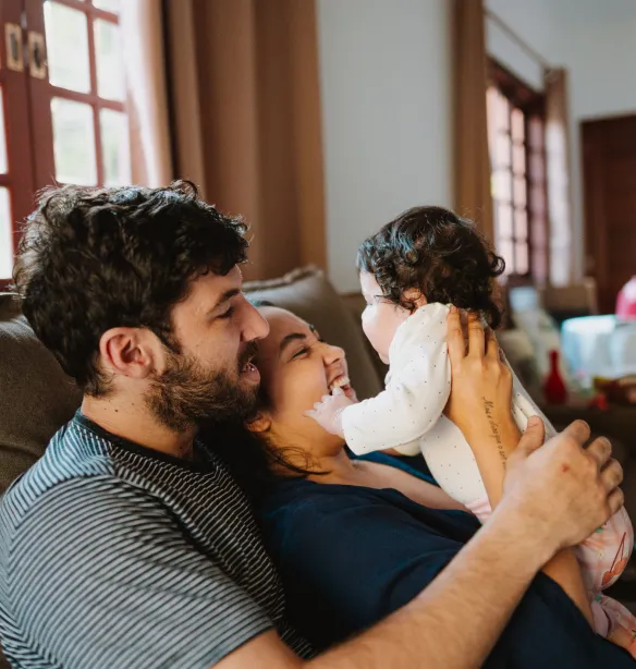 Father playing with toddler on the sofa