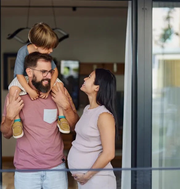 Happy Asian pregnant woman talking to her family while spending their time together on a balcony.