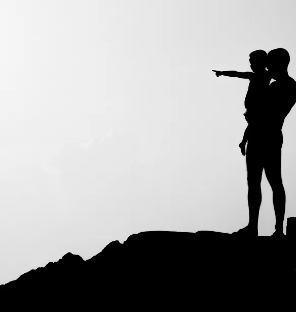Silhouette of man carrying child
