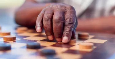 African elder playing chess, making a move. Langebaan, Western Cape, South Africa.