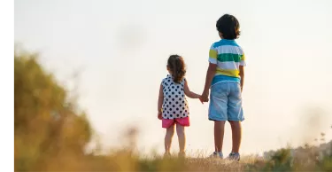 Portrait of female toddler holding hands with a little boy looking into the distance