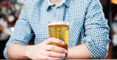 Young man in bar, mid section