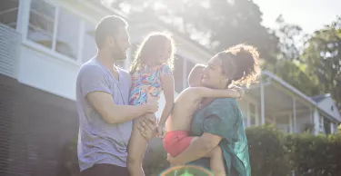 Australian aboriginal family enjoying in the garden at home on a sunny day