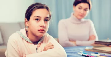 Mother talking seriously with her teenage daughter about poor school performance