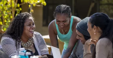 Young aboriginal students studying together outdoors in the sun in Australia.
