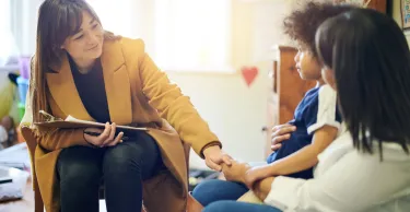 Mother, child and psychologist consultation in office for support, help and mental health.