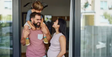 Happy Asian pregnant woman talking to her family while spending their time together on a balcony.