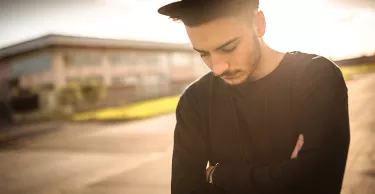 Young adult man looking pensive at dusk