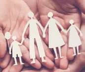 Adult and children hands holding paper family cutout, family home, adoption, foster care, homeless support, family mental health, autism support, domestic violence concept.
