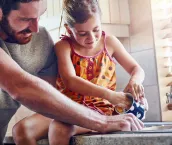 Man with child washing dishes