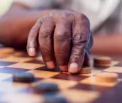 African elder playing chess, making a move. Langebaan, Western Cape, South Africa.