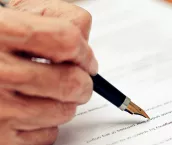 Close up of a senior person filling in a paper form
