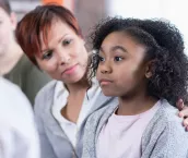 School counsellor comforts elementary age student while in group therapy session. School counsellor comforts elementary age student while in group therapy session.