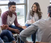 As the therapy group members listen, the teen boy shares his life experiences.