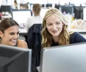 Multiracial businesswomen using computer at work, looking at screen