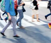 Crowds of people crossing a city street