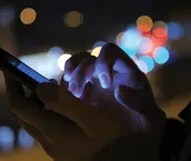 Close-up shot of woman hands with smartphone in the city at night.