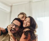 Cheerful girl having fun with her parents at home.
