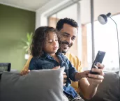 Father and son using smartphone at home Father and son using smartphone at home