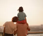 Asian Chinese family with one kids enjoying amazing view of setting sun outdoors in spring.