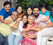 Portrait of Happy indian joint family sitting together at home. Asian senior and young couple with their kids having and laughing.