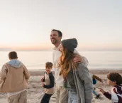 Photo of a young family, having a relaxed walk down the beach by the ocean