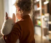 Toddler girl holding her favourite unicorn plush toy
