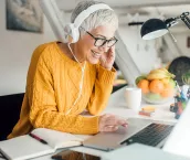 Woman using laptop and wearing headphones