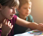 Teenage girl and her little brother are painting with watercolor paints.