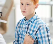 A teenage boy getting his heart checked by a doctor