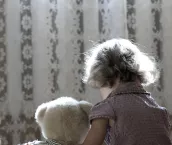 Depressed little girl hug a teddy bear