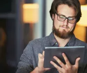 Shot of a young businessman using a digital tablet during a late night at work