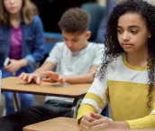Teen girl sitting in a classroom looking pensive Teen girl sitting in a classroom looking pensive