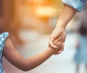 Mother and daughter holding hand together in vintage color tone