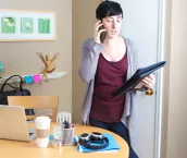 Young woman millennial working in home office telecommuting using laptop computer, mobile devices doing business function. Young woman millennial working in home office telecommuting using laptop computer, mobile devices doing business function.