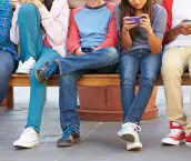 Group of youths playing with mobile devices.