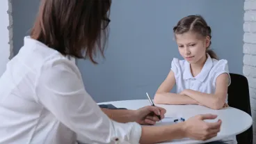 Communication session of school psychologist and girl 9, 10 years. Child tells psychotherapist their experiences, mental health of children.