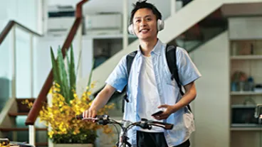 Man with headphones pushing bike