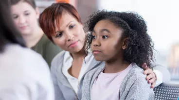 School counsellor comforts elementary age student while in group therapy session. School counsellor comforts elementary age student while in group therapy session.