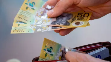 Hands holding wallet with Australian dollars and make a payment - Coronavirus finance struggle concept Hands holding wallet with Australian dollars and make a payment - Coronavirus finance struggle concept