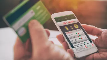 Cropped close up of hands betting on sports with smartphone Cropped close up of hands betting on sports with smartphone