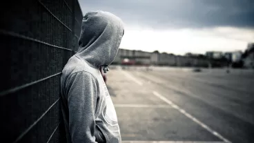 Lonely hooded man in a desolate urban environment Lonely hooded man in a desolate urban environment