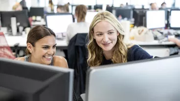 Multiracial businesswomen using computer at work, looking at screen
