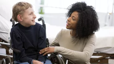 A physical therapist is working with a child in the hospital that has cerebral palsy. A physical therapist is working with a child in the hospital that has cerebral palsy.