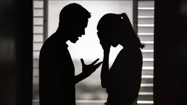 Silhouette of a man and woman having an argument at home.