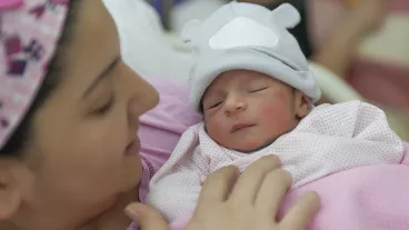 A newborn baby enters the world and mother holding newborn baby girl in the hospital.