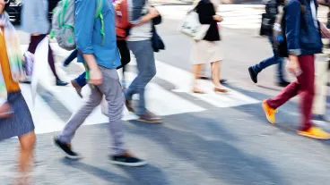 Crowds of people crossing a city street